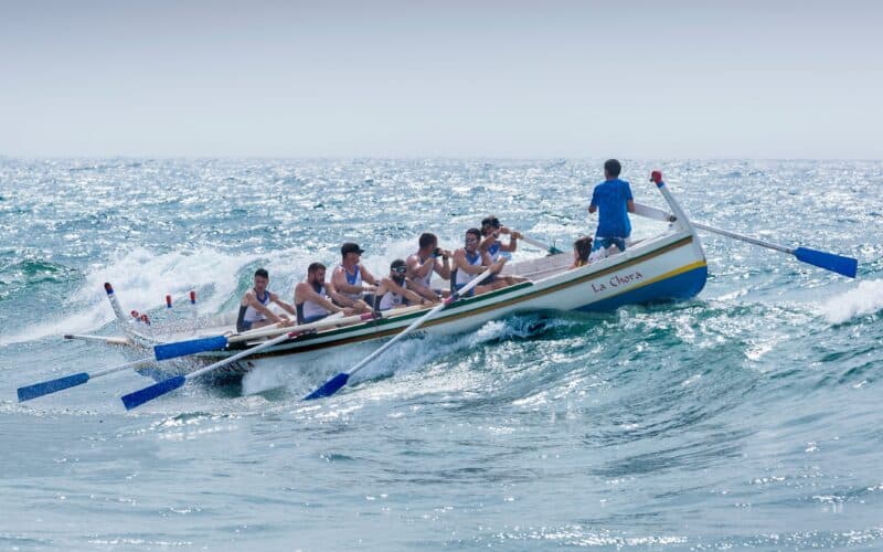 Rowing team battling waves